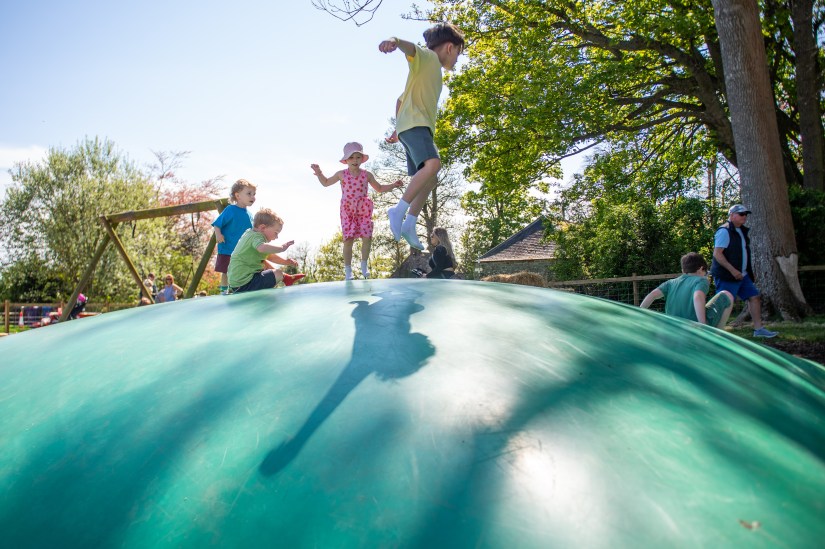 Children at East Scryne Fruit playing on the giant inflatable pillow with traditional wooden swings seen in the background.  Photograph © The Courier, D C Thompson, 2024